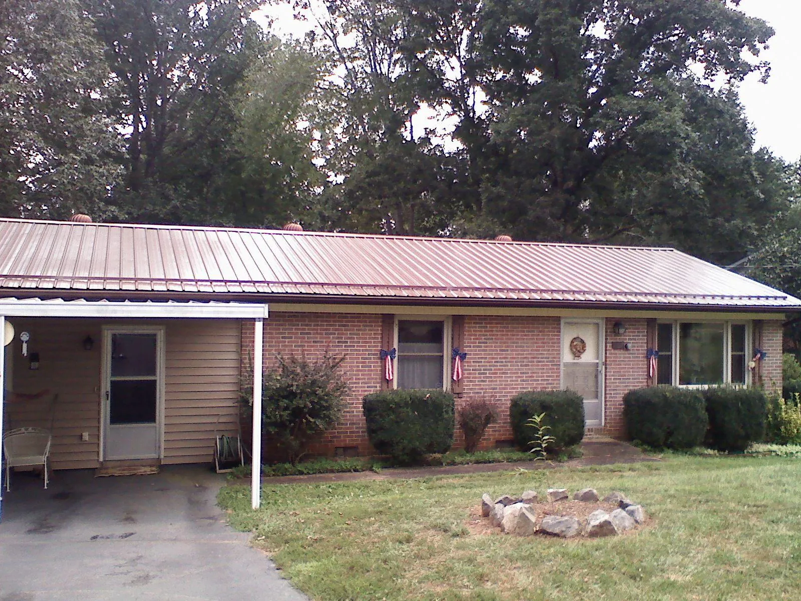 Bronze metal roof and carport on a brick ranch home — Roof Repair work by our crew in Port Richey